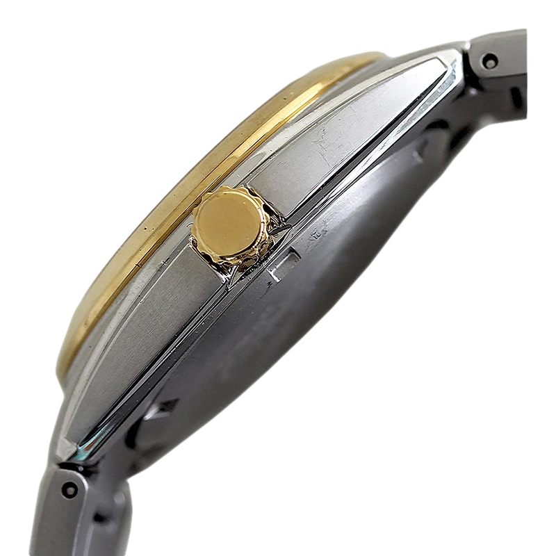 Close-up van een gouden en zilveren horloge met kroon en armband