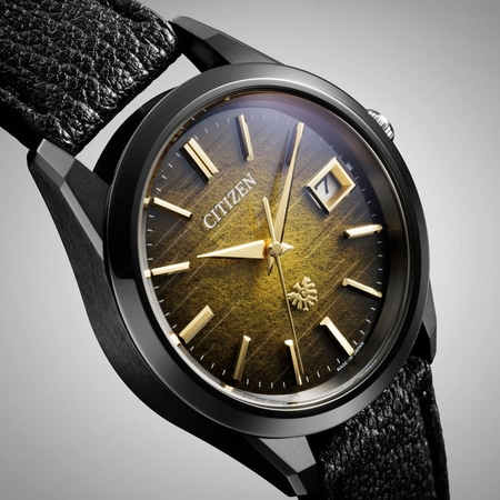 Citizen-Uhr mit schwarzem Gehäuse, goldenen Zeigern und Markierungen, Lederarmband und Datumsanzeige.