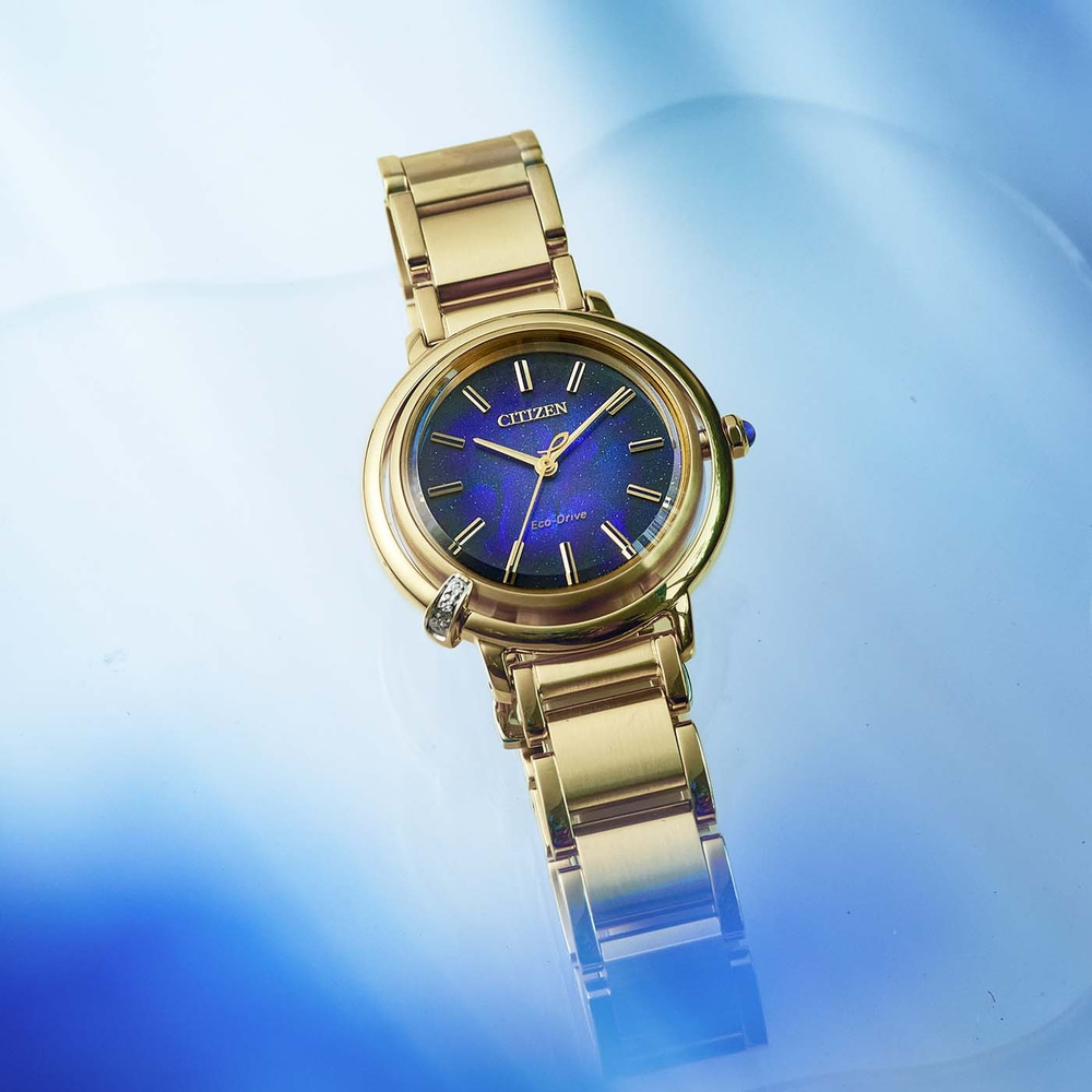 Gouden Citizen horloge met blauwe wijzerplaat op blauwe achtergrond.