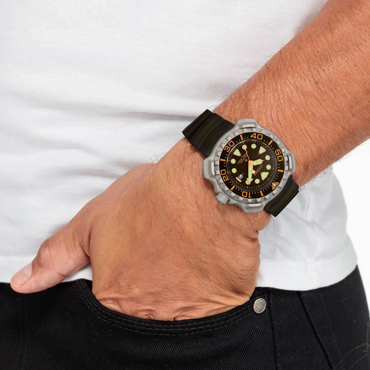 Man met horloge, hand in zak, wit shirt, zwarte jeans, close-up