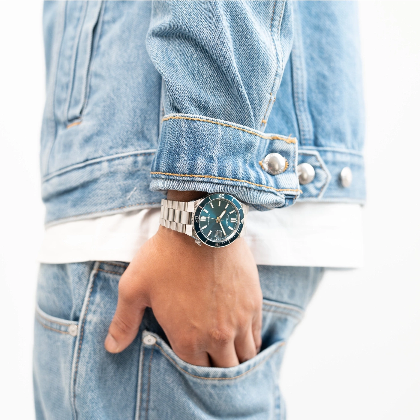 Man draagt een spijkerjack en spijkerbroek met een horloge.