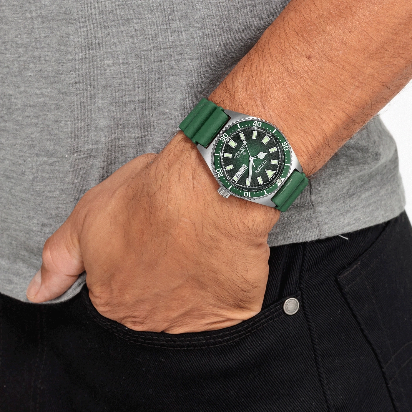 Man met groen horloge en groene band, hand in de zak.