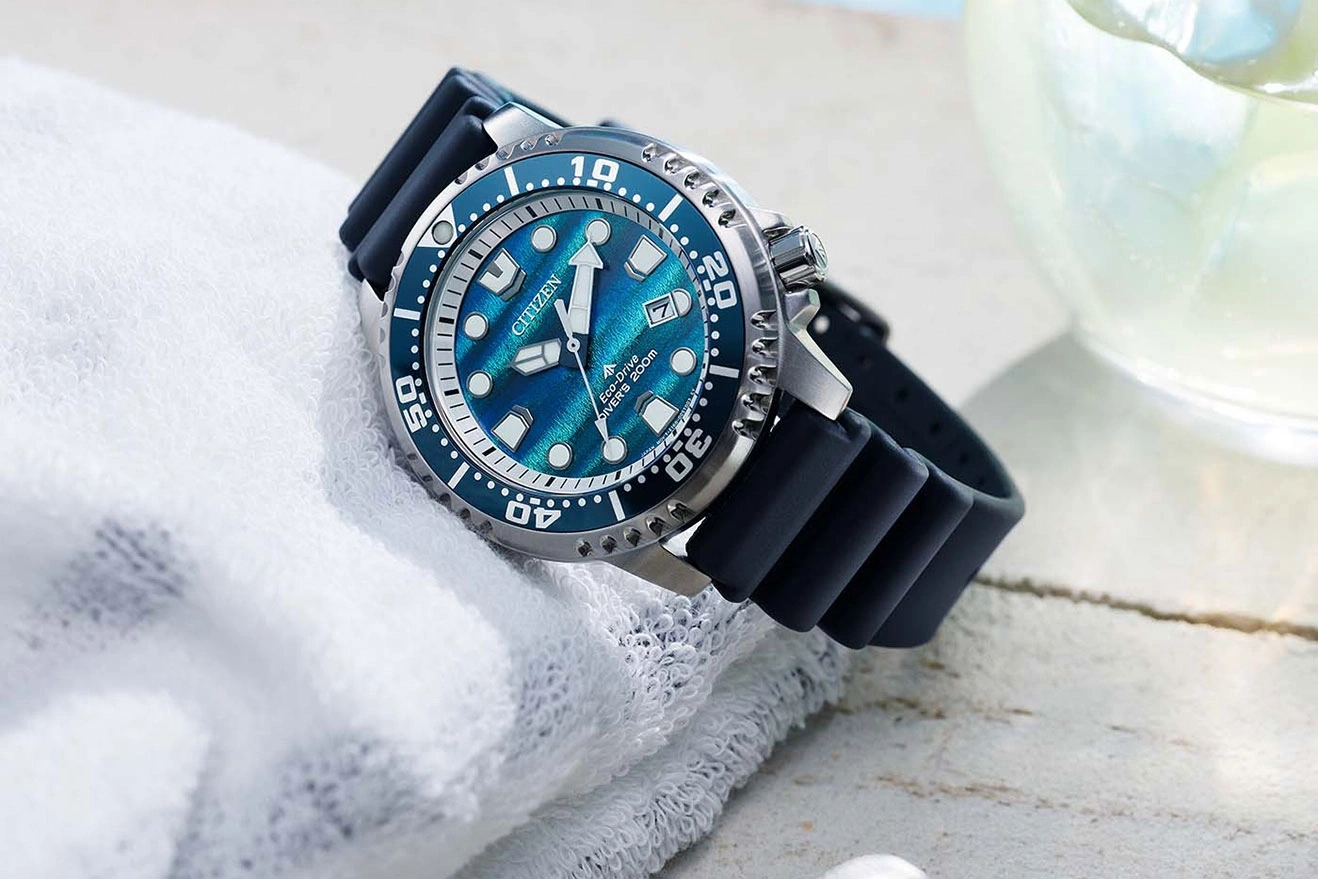 Een blauw Citizen Eco-Drive duikhorloge met rubberen band ligt op een witte handdoek.