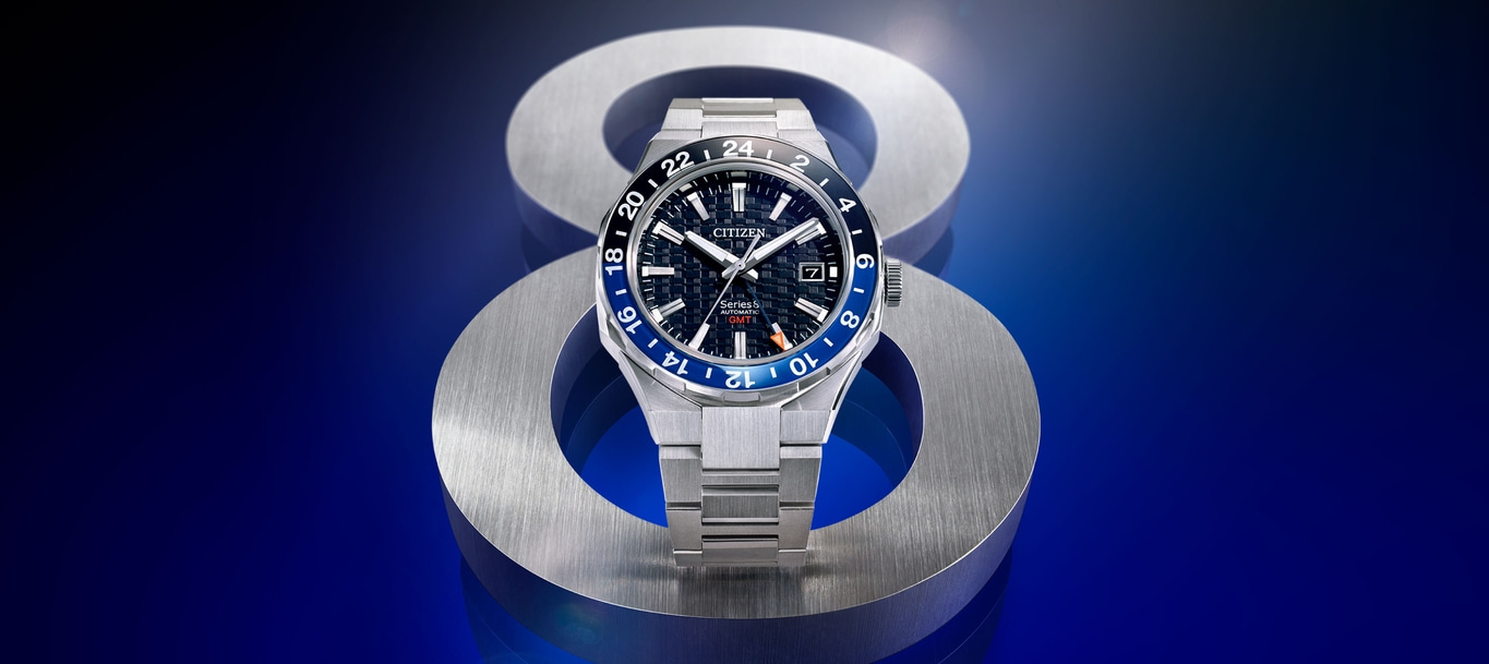 Citizen Series 8 automatische GMT-horloge op metalen standaard, blauwe achtergrond.