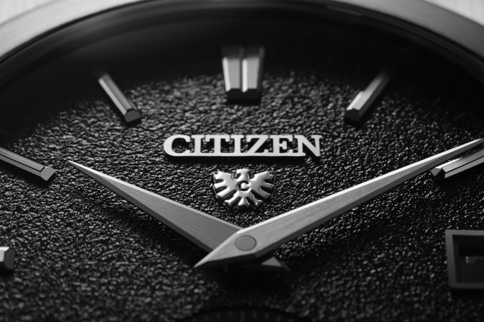 Close-up van een Citizen horlogekast met zilveren wijzers en logo.