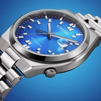 Close-up van een blauw Citizen automatisch horloge met metalen band.