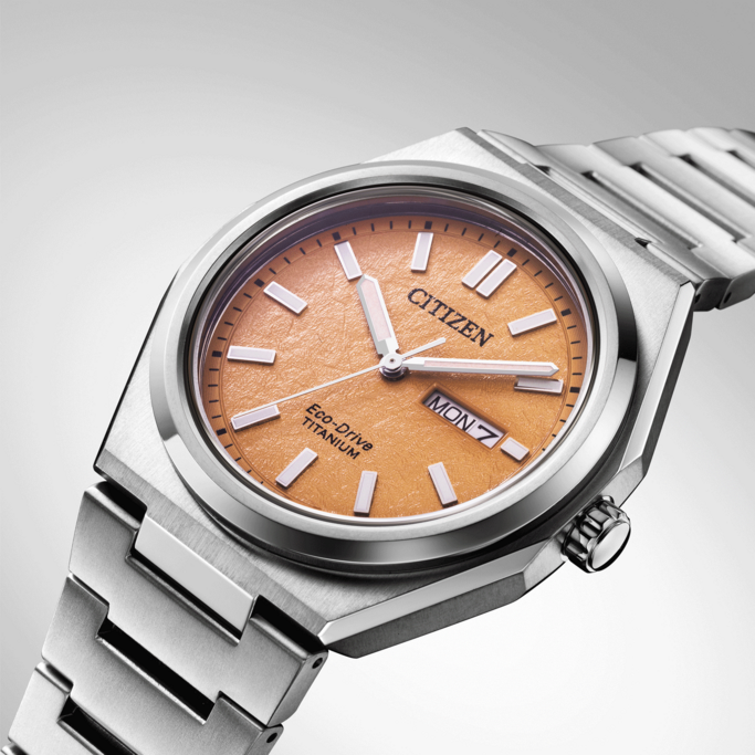 Citizen horloge met oranje wijzerplaat en titanium band, Eco-Drive technologie.