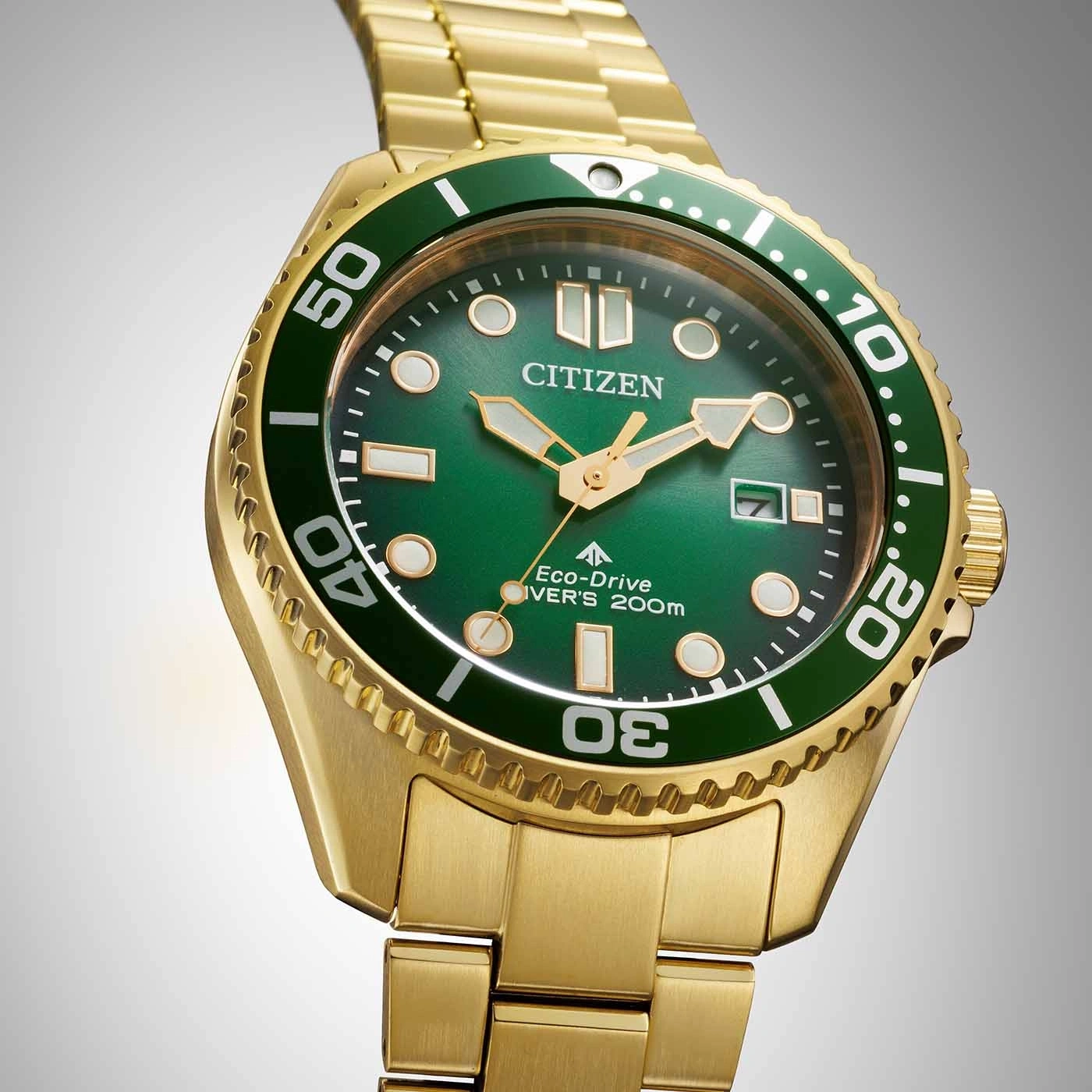 Gouden Citizen horloge met groene wijzerplaat en bezel, close-up.
