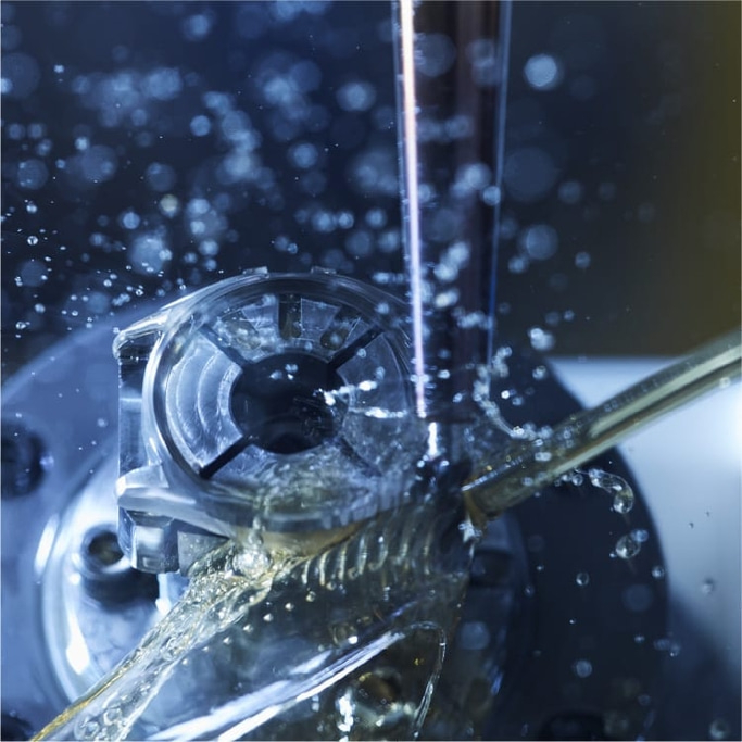 Close-up van een machinegereedschap met waterspatten, industrieel proces.