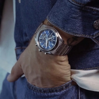 Een man met een blauw Citizen horloge en een spijkerjack