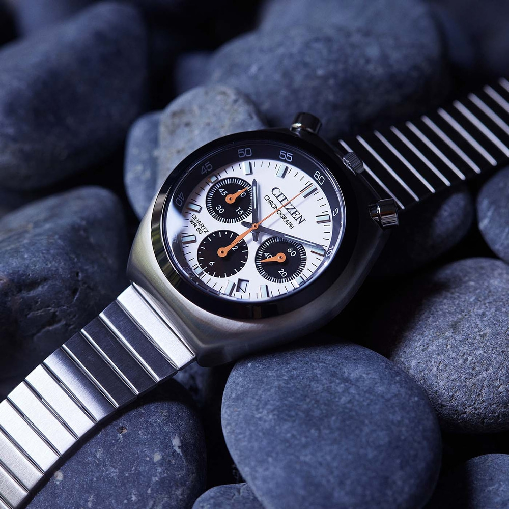 Close-up van een Citizen chronograaf horloge op donkere stenen.