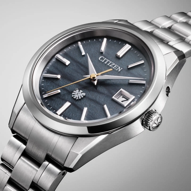 Citizen horloge met donkerblauwe wijzerplaat en zilveren band, elegant design.