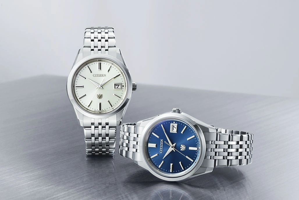 Twee Citizen horloges met zilveren bandjes en verschillend gekleurde wijzerplaten.