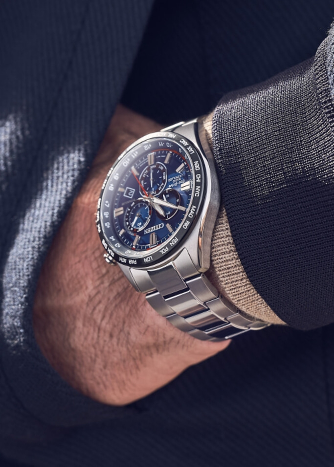 Close-up van een Citizen horloge om een pols, met een blauwe wijzerplaat en zilveren band.