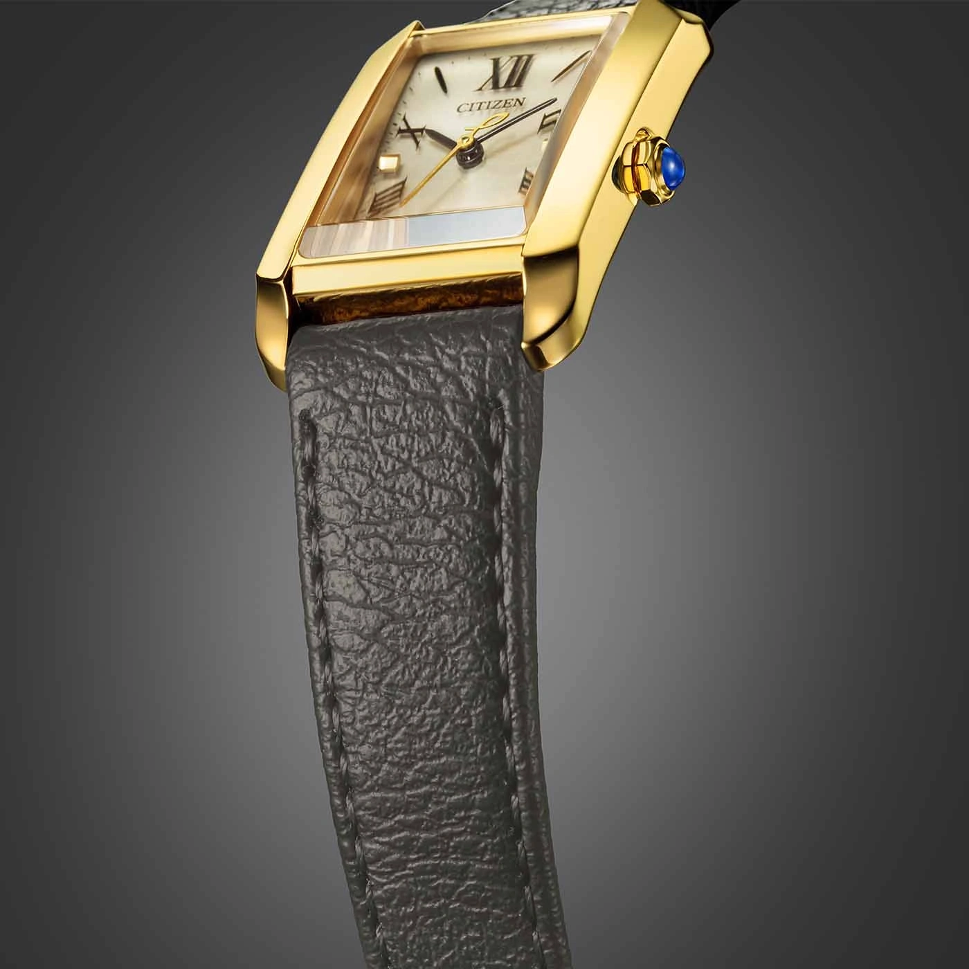 Gouden horloge met een rechthoekige wijzerplaat en een leren band.