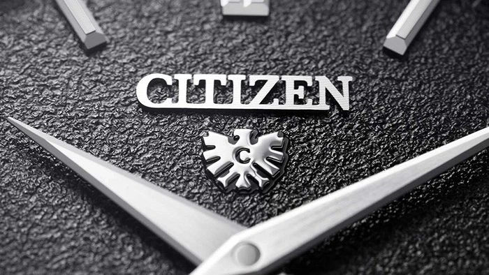 Close-up van een Citizen horlogekast met de merknaam en het logo.