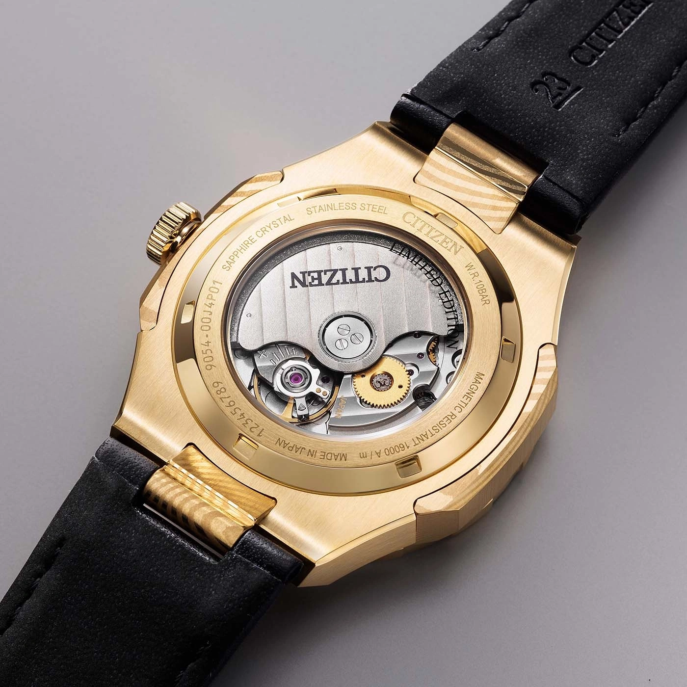 Close-up van de achterkant van een gouden Citizen horloge met automatisch uurwerk en inscripties.