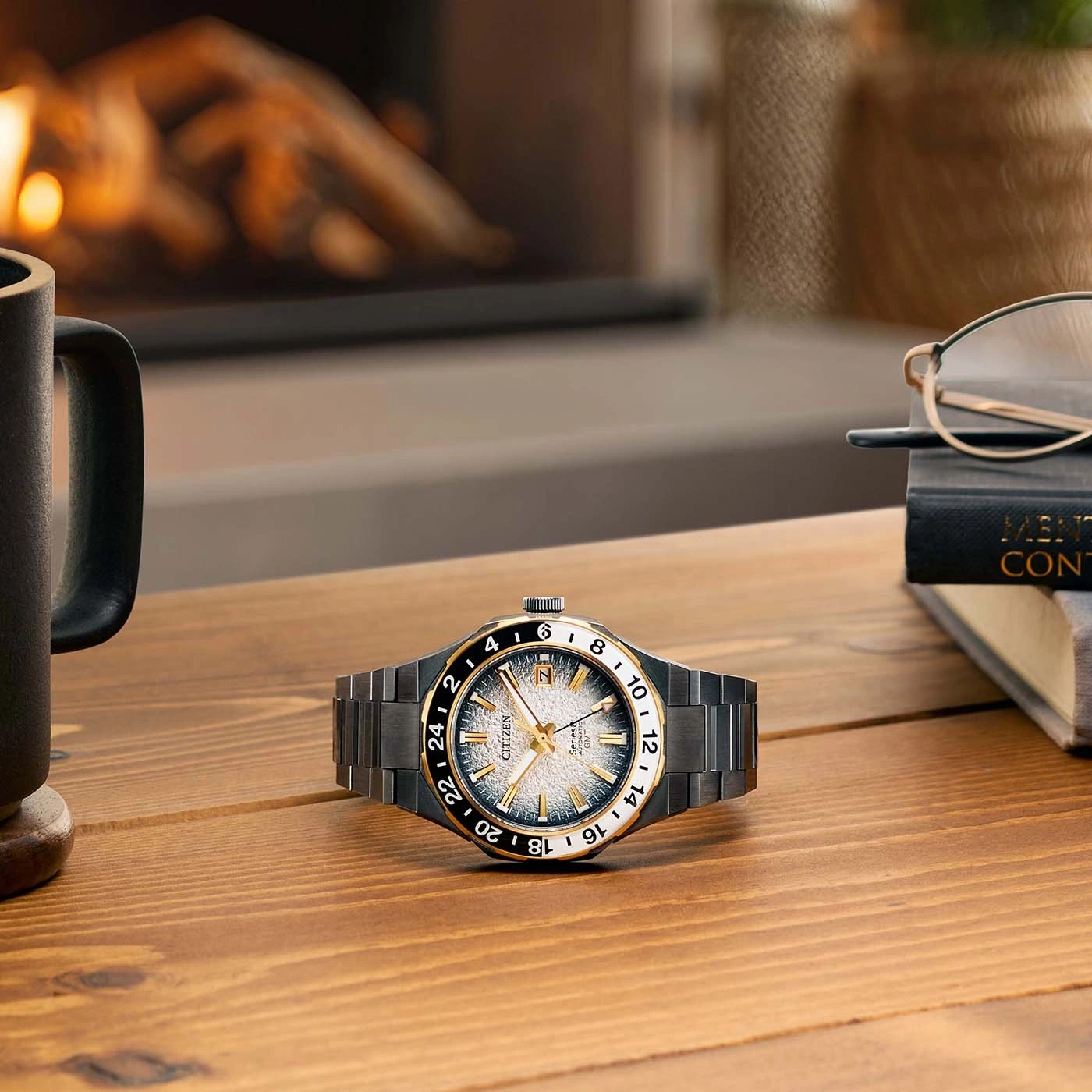 Horloge op een houten tafel met een mok, bril en een boek.