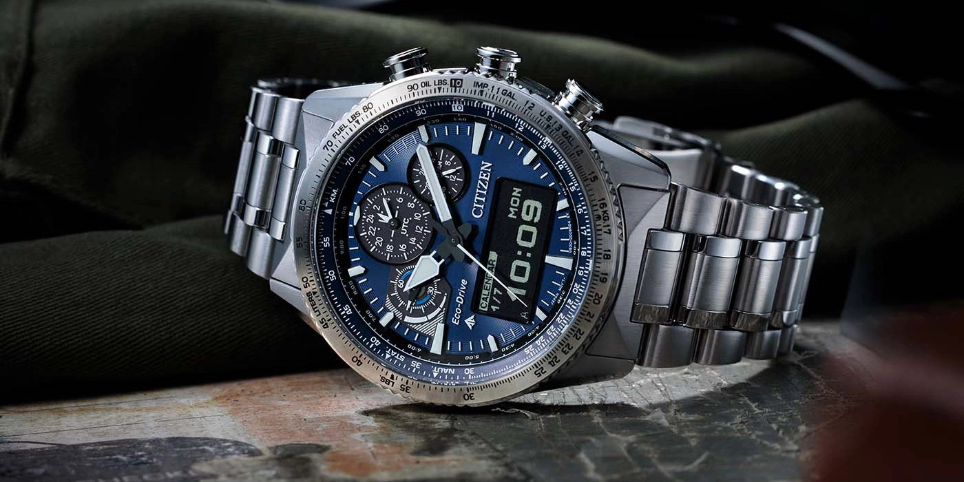 Citizen horloge met blauwe wijzerplaat, digitale display en roestvrijstalen band op een oppervlak.