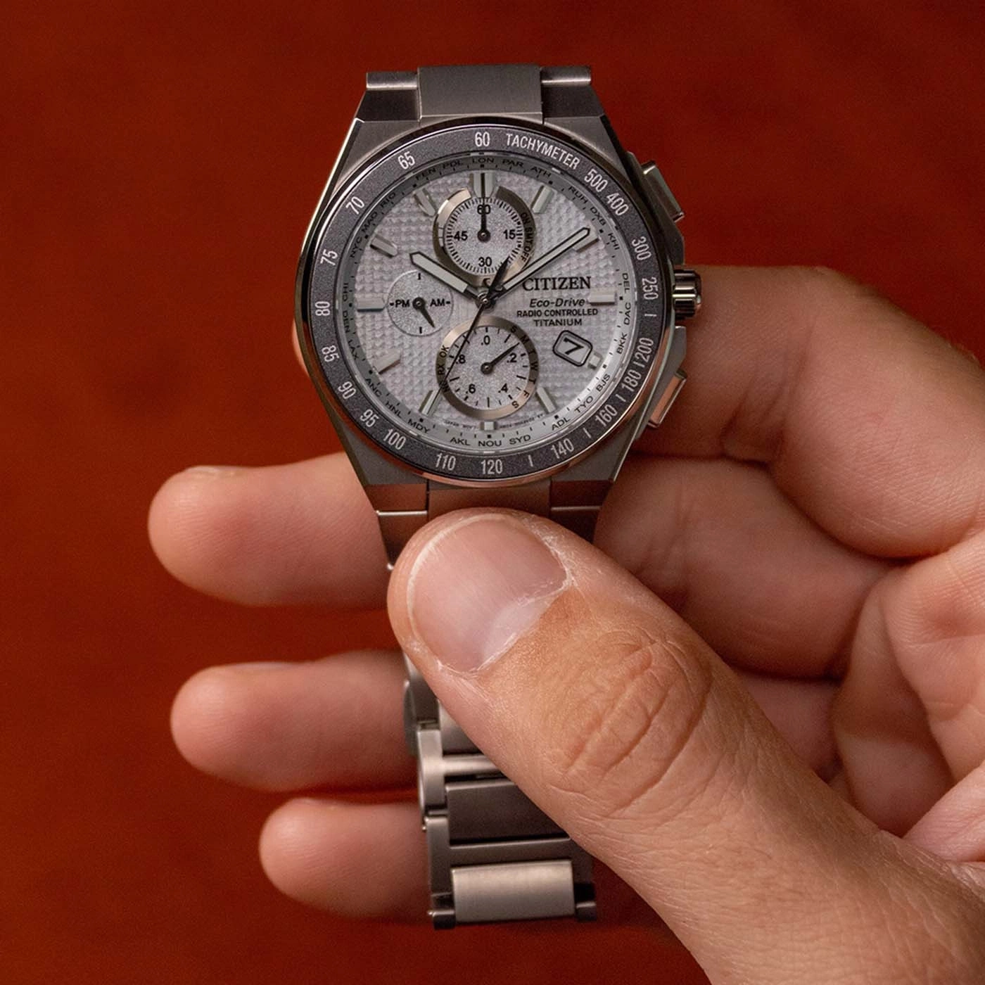 Een man houdt een Citizen Eco-Drive horloge met zilveren wijzerplaat vast