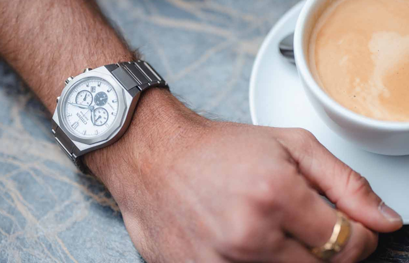 Man met Citizen-horloge en een kopje koffie ernaast