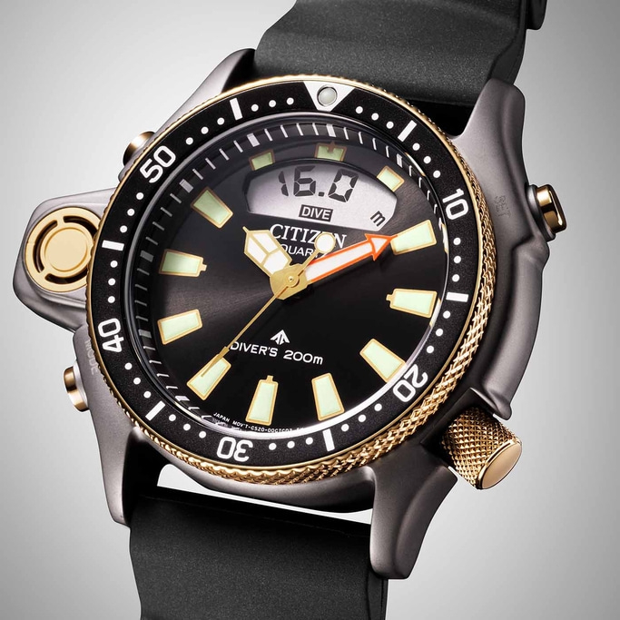 Citizen duikhorloge met zwarte wijzerplaat, gouden accenten en digitale diepte-aanduiding.