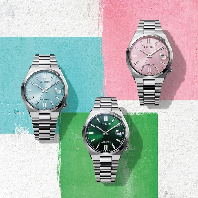 Drie Citizen horloges met verschillende gekleurde wijzerplaten op een kleurrijke achtergrond.