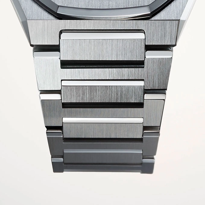 Close-up van een metalen horlogeband met geborstelde metalen afwerking en witte accenten.