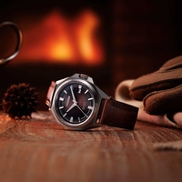 Citizen horloge op houten tafel met open haard achtergrond en handschoenen