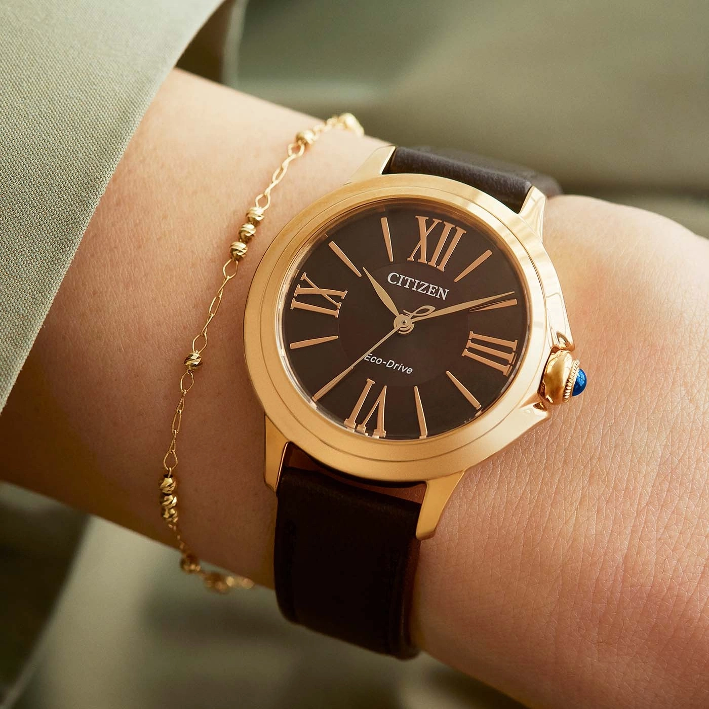 Close-up van een Citizen horloge om een pols met een gouden armband.