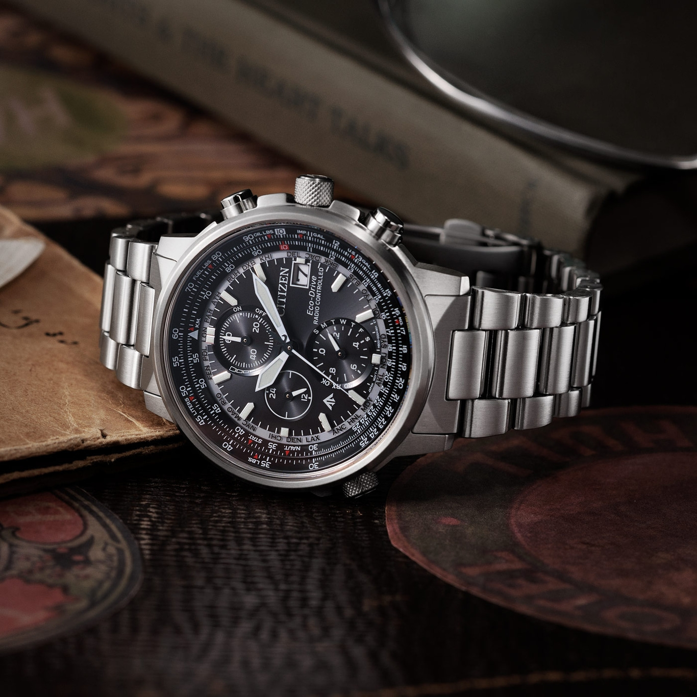 Citizen horloge met zwarte wijzerplaat en zilveren band op houten oppervlak.