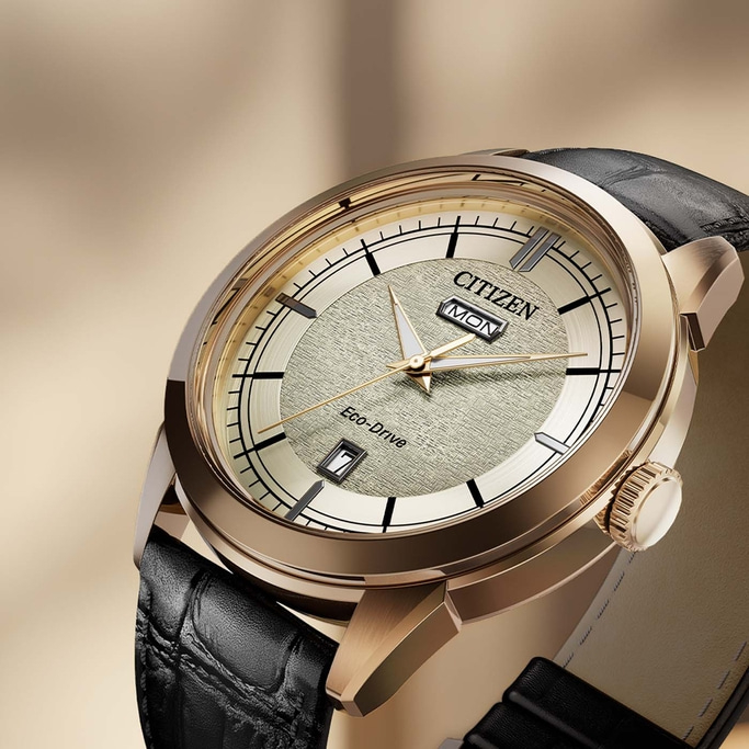Close-up van een Citizen Eco-Drive horloge met gouden wijzerplaat en zwarte leren band.