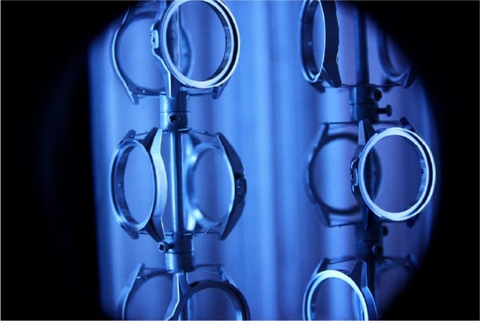 Horloge onderdelen op een rek, blauw verlicht, close-up, industrieel beeld.