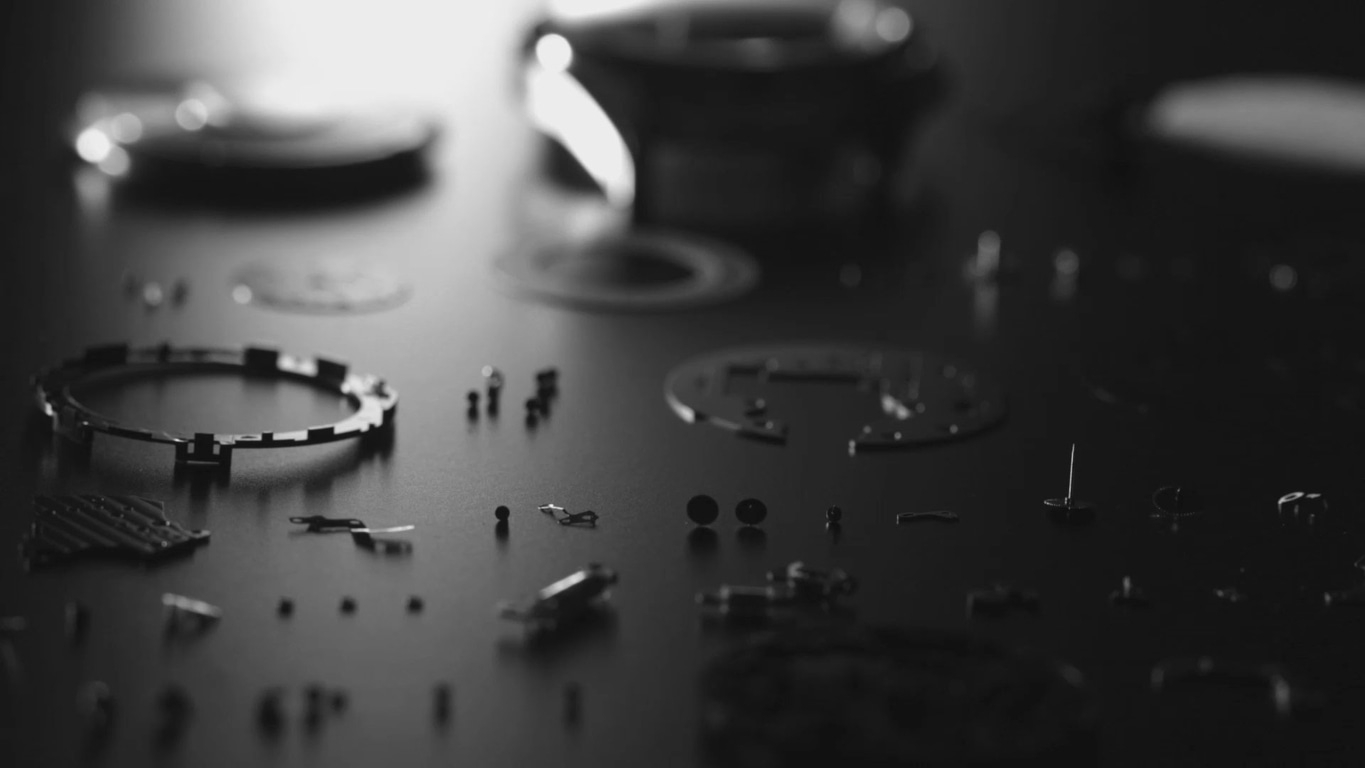 Horloge onderdelen gedemonteerd op donker oppervlak, monochroom, close-up.