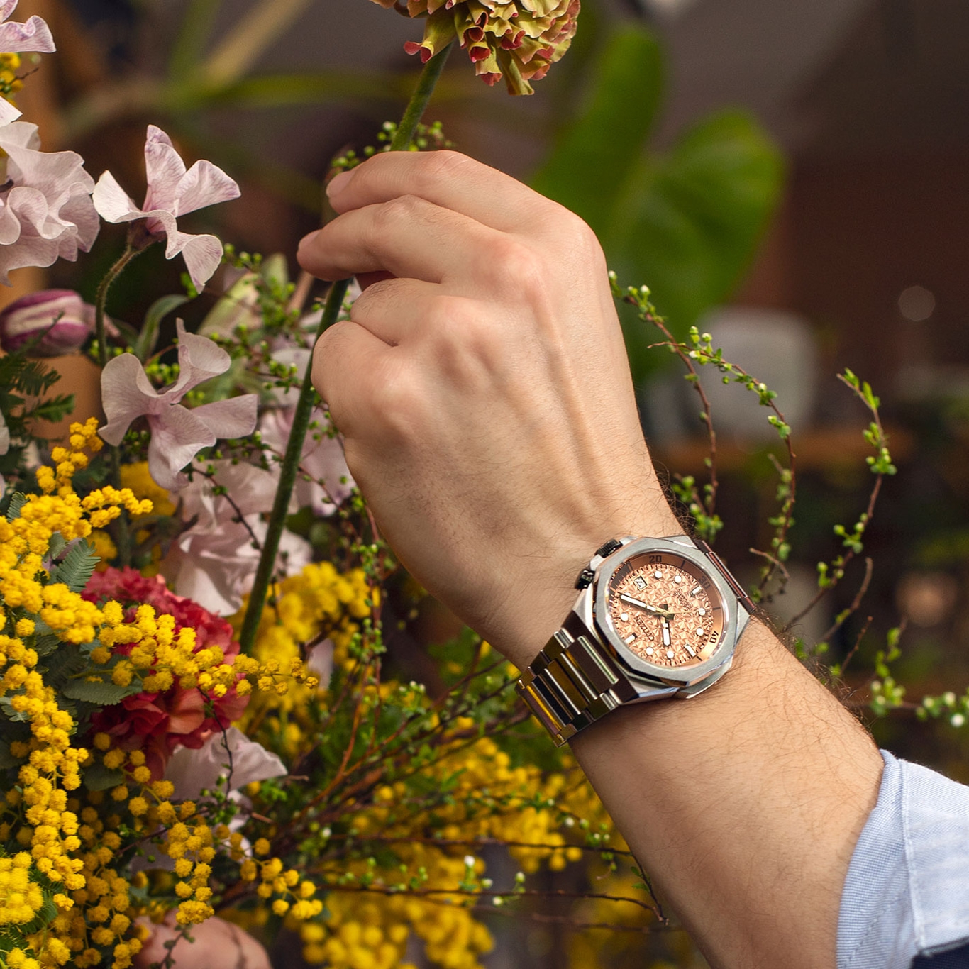 Heren polshorloge met bloemen. Zilveren horloge met een roségouden wijzerplaat.