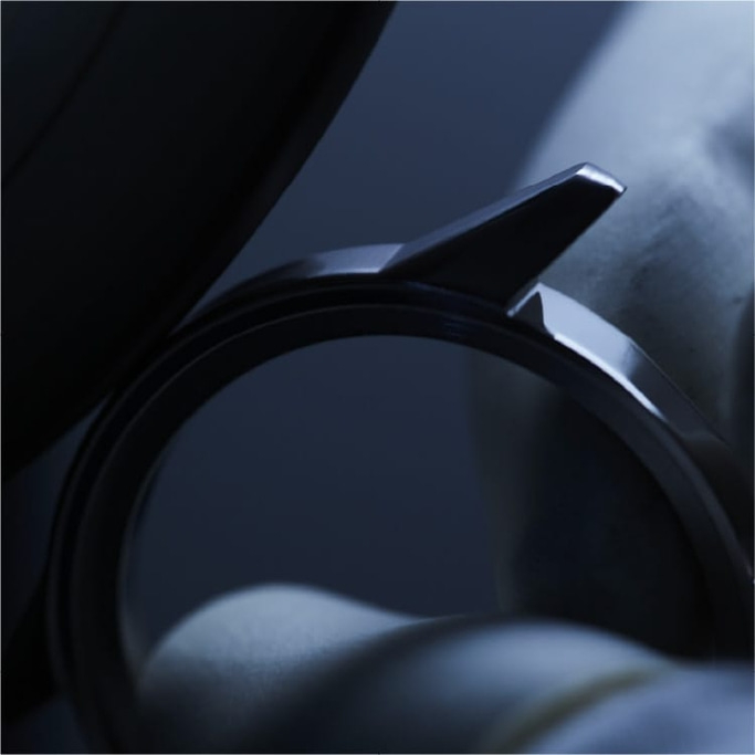 Close-up van een horloge met een glanzende metalen band en details.