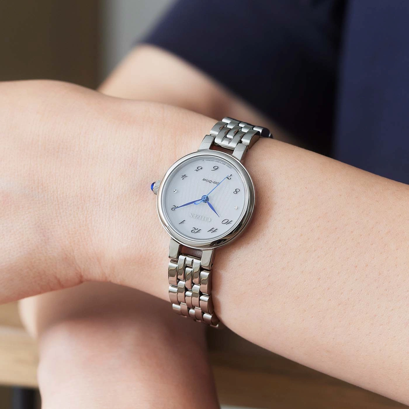 Citizen horloge om de pols, zilveren band, witte wijzerplaat, blauwe wijzers, elegant design