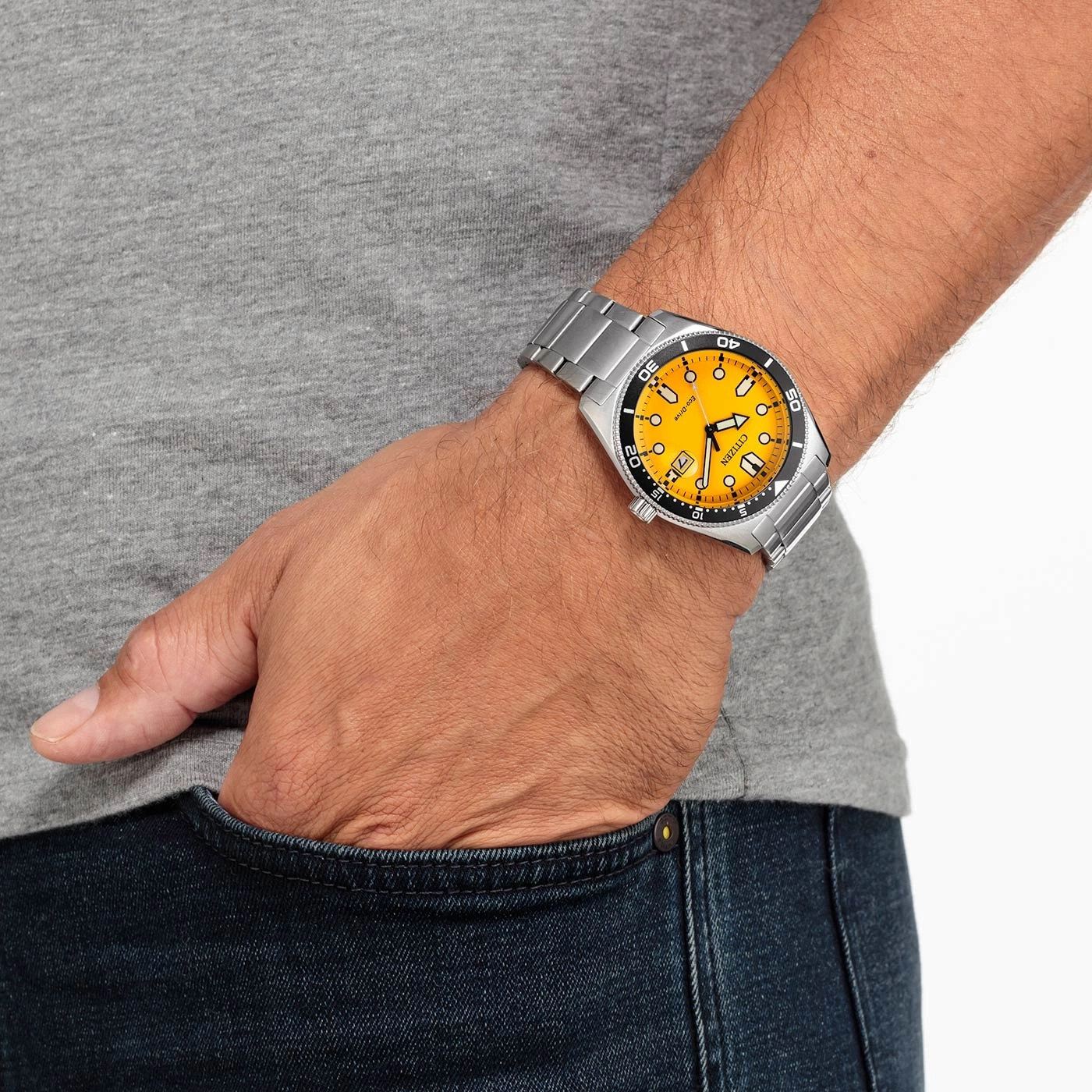 Man draagt Citizen horloge met gele wijzerplaat en zilveren armband.