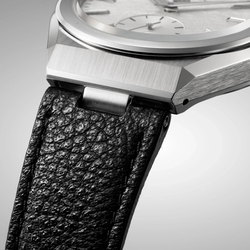 Close-up van een luxe horloge met een zwarte leren band en zilveren details.
