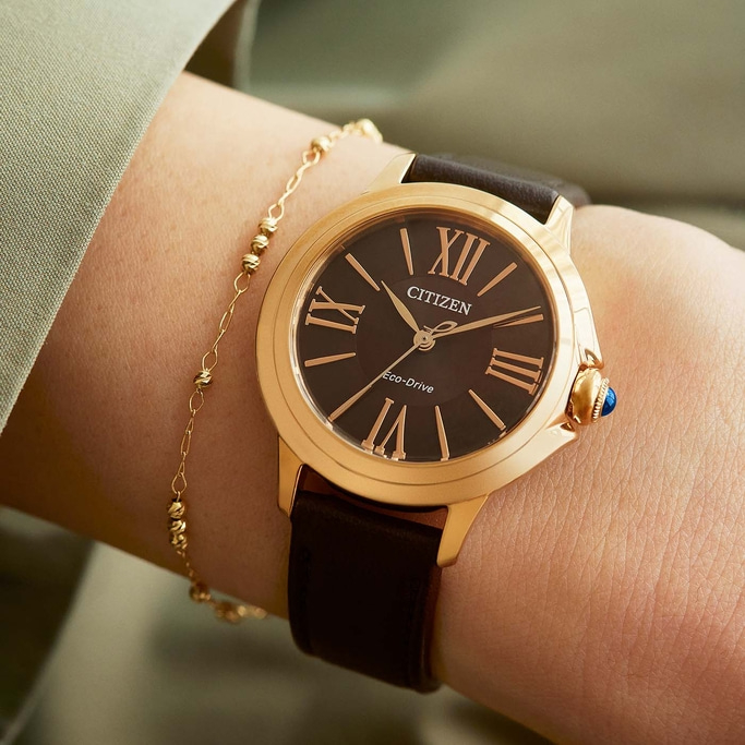 Close-up van een Citizen horloge om een pols met een gouden armband.