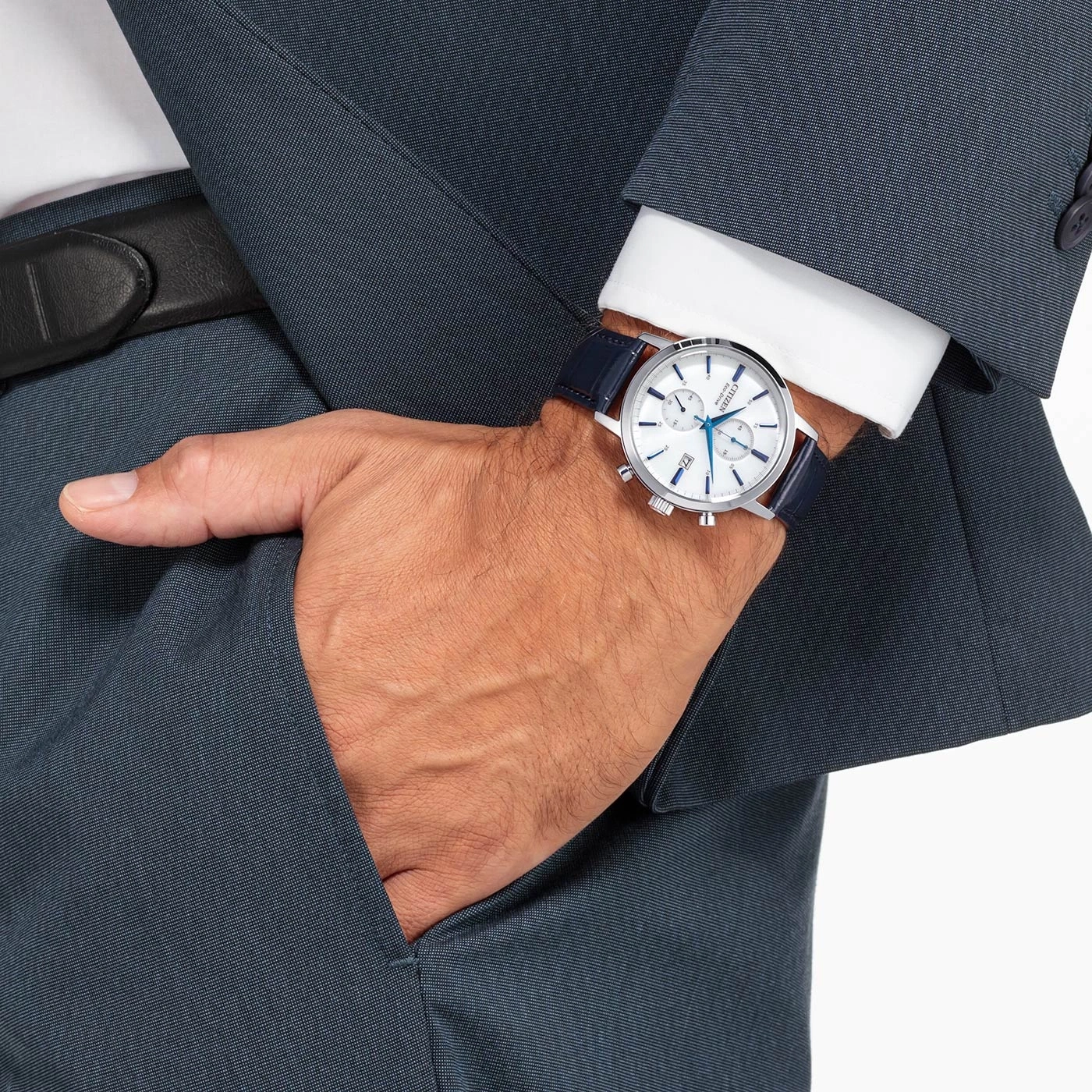 Man met horloge en pak, steekt zijn hand in zijn zak.
