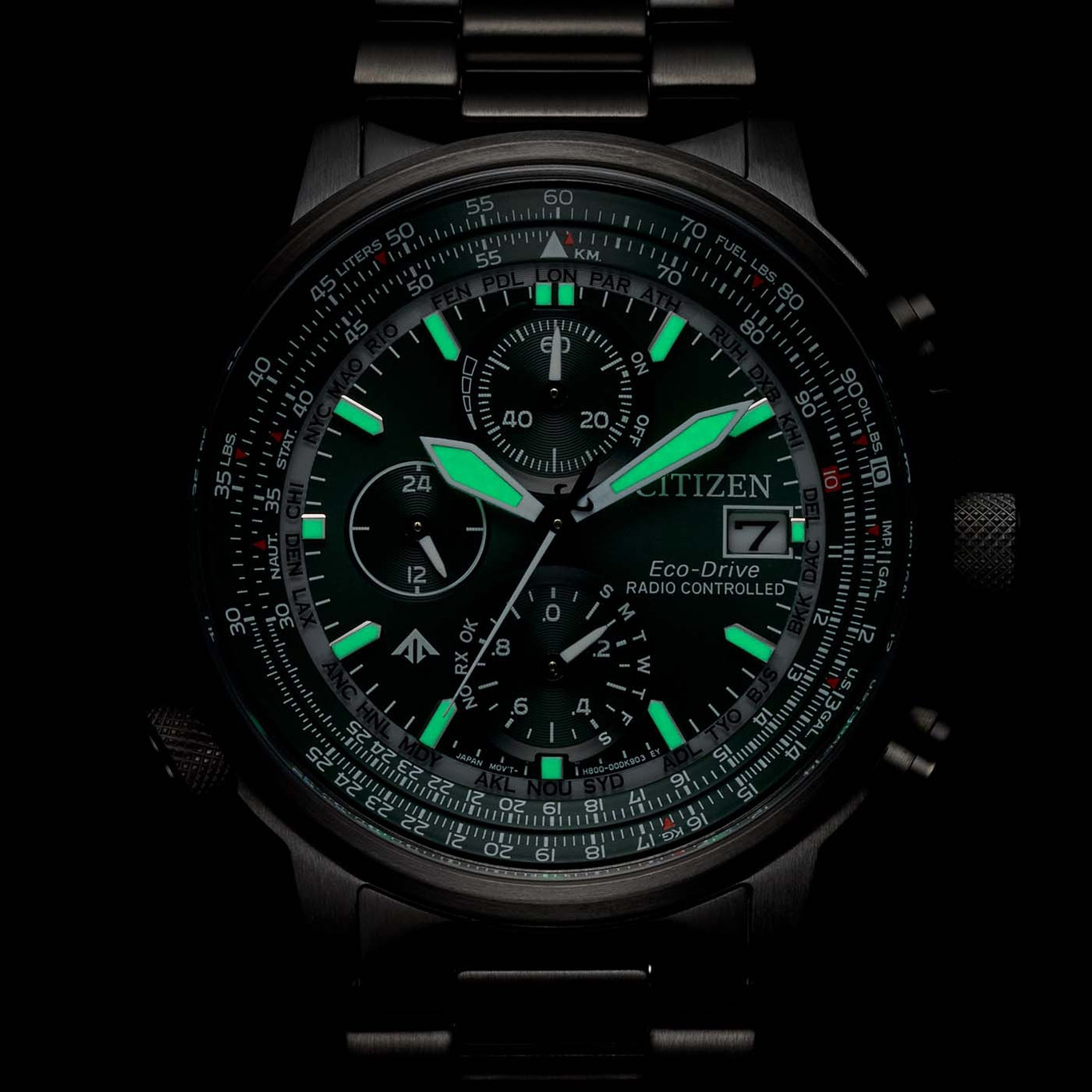 Citizen horloge met groene accenten, lichtgevende wijzers en meerdere wijzerplaten, zwarte achtergrond.