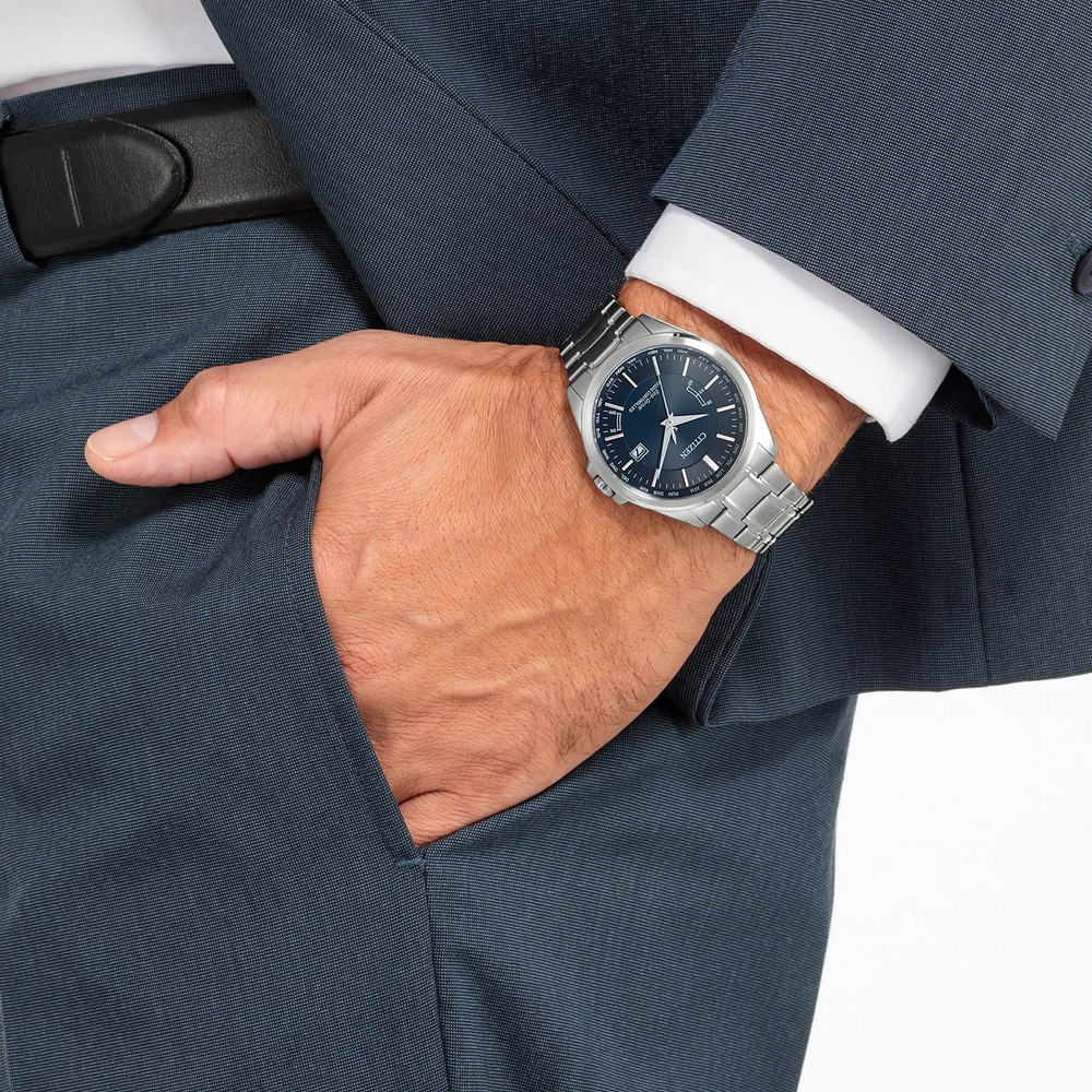 Man in pak met horloge, hand in zak, formele kleding, zaken