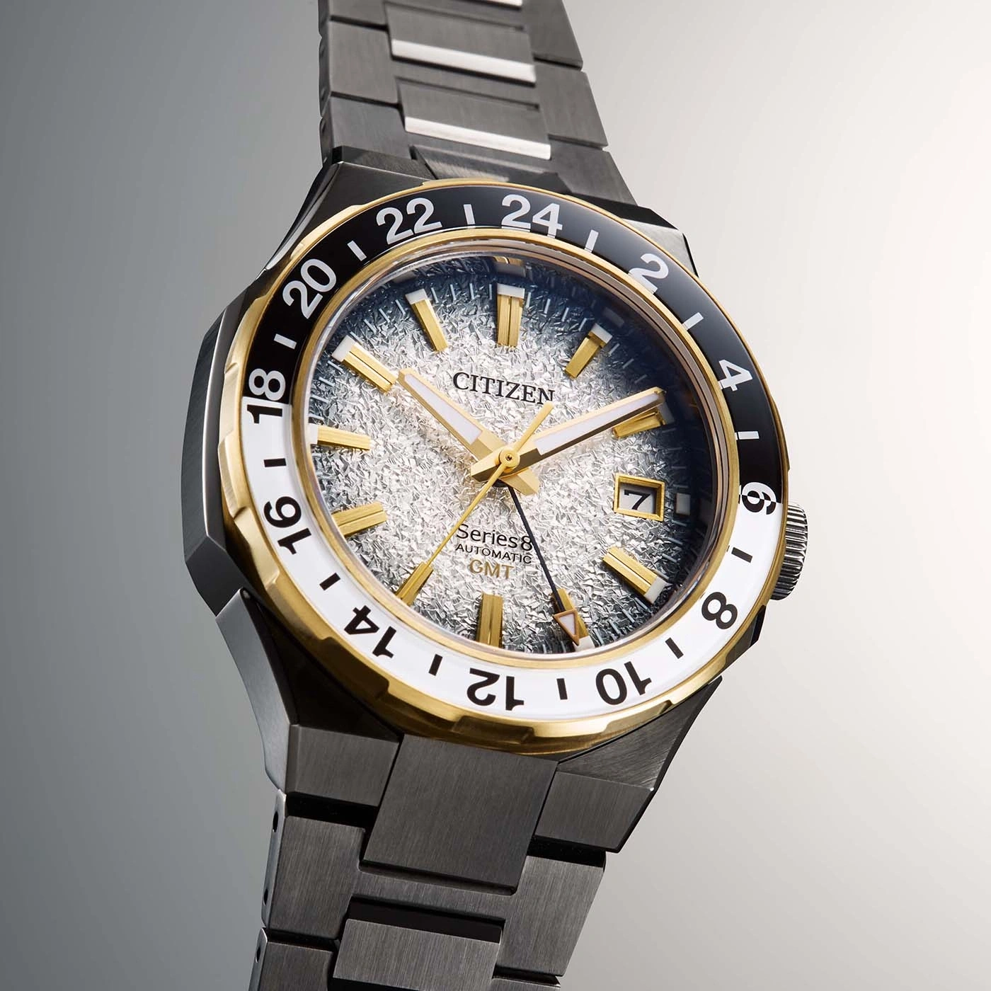 Citizen horloge met gouden accenten en een getextureerde wijzerplaat, GMT-functie.