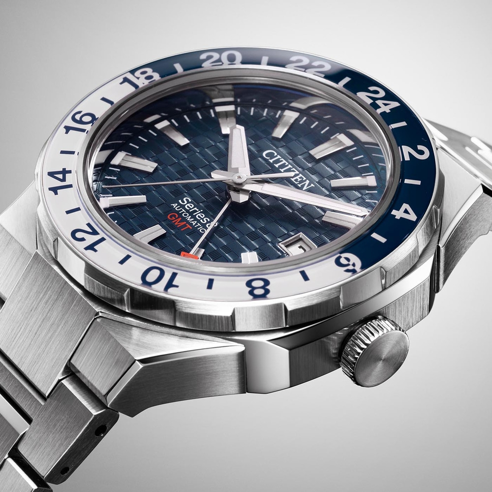 Close-up van een Citizen horloge met een blauw-witte bezel en een metalen band.