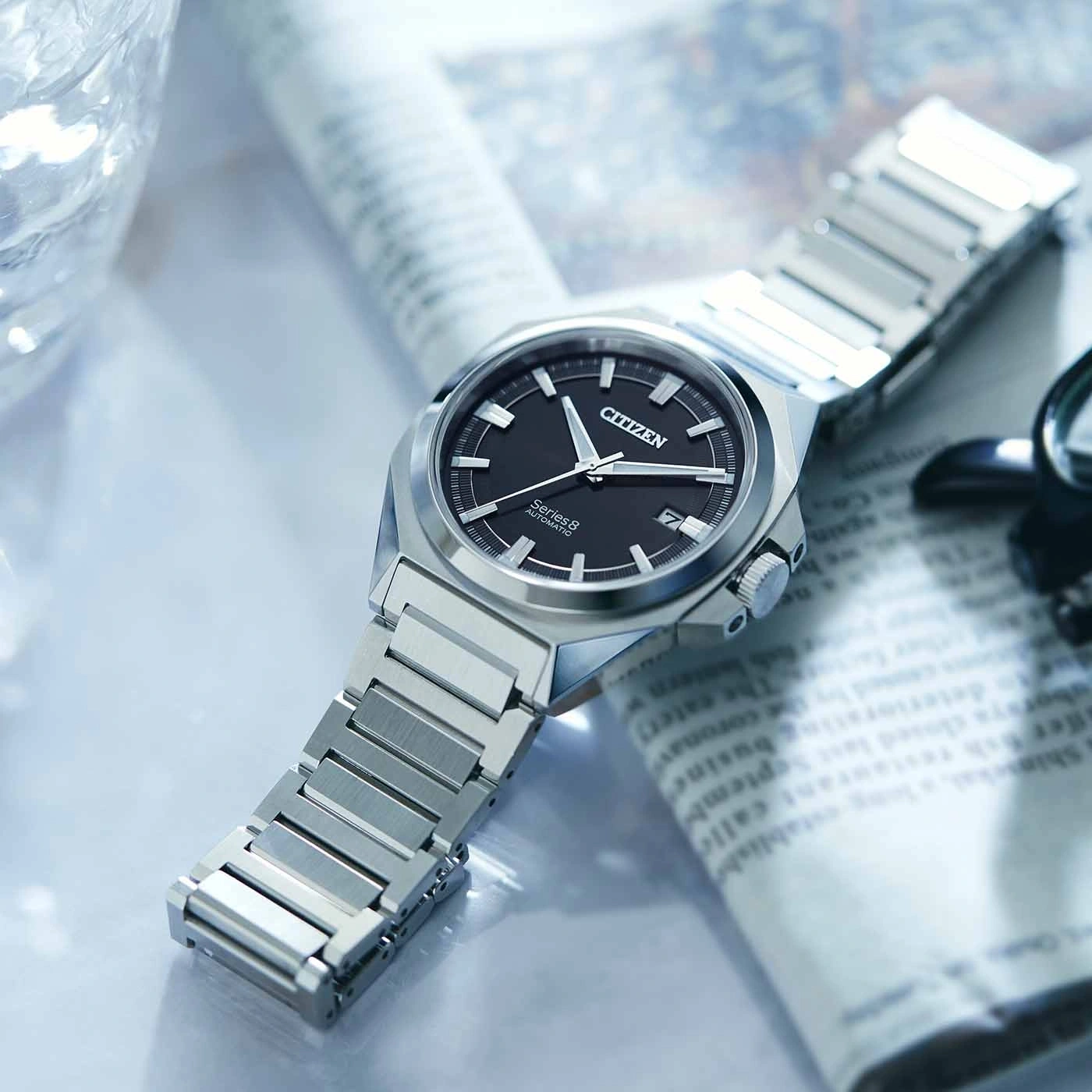 Citizen Series 8 horloge op krant, zwarte wijzerplaat, zilveren armband, close-up