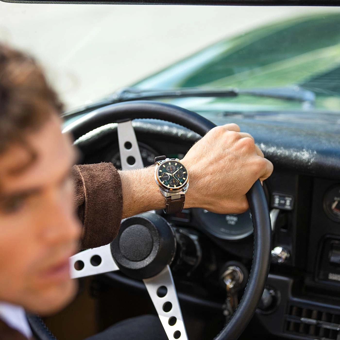 Man bestuurt oldtimer, draagt horloge