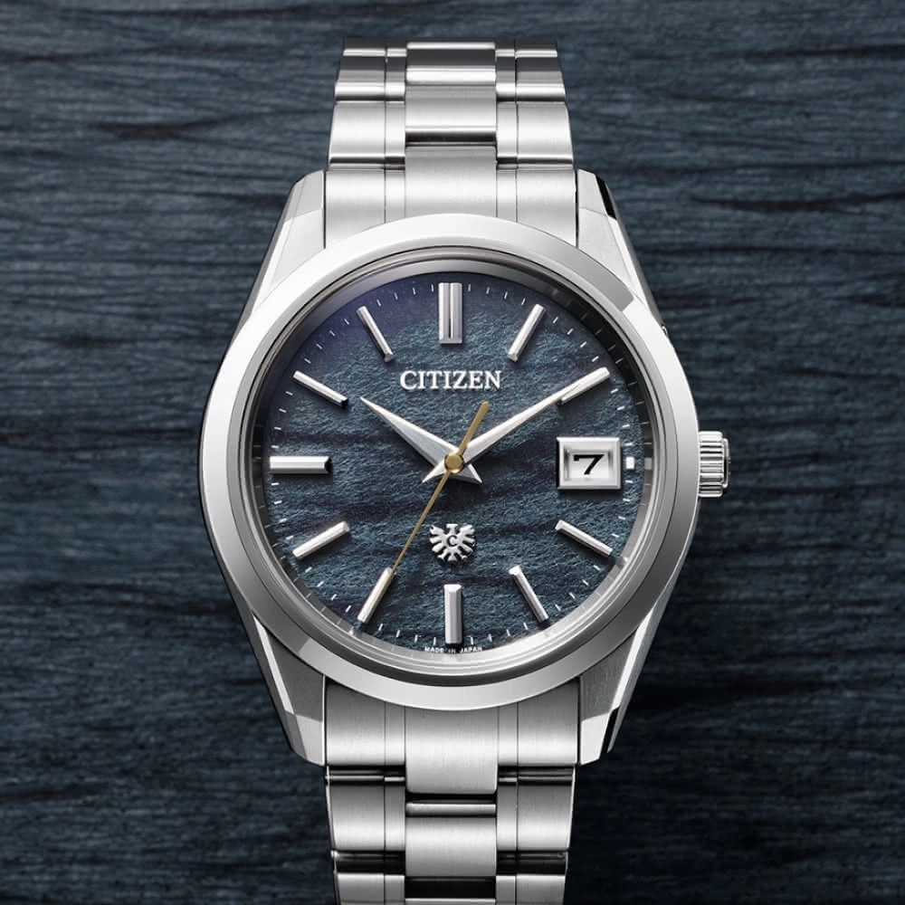 Citizen horloge met blauwe wijzerplaat en zilveren band op donkere achtergrond