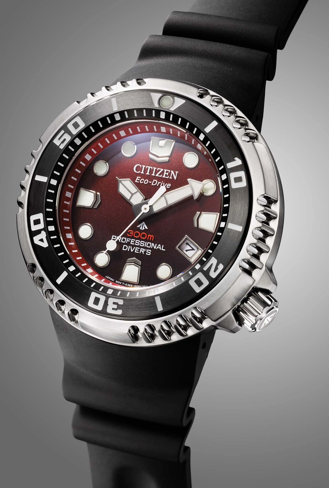 Close-up van een Citizen Eco-Drive horloge met rode wijzerplaat en zwarte band.