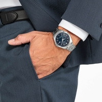 Man in pak met horloge, hand in zak, formele kleding, zaken